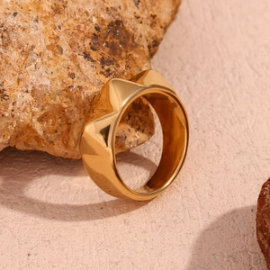 Macro shot of 18K gold plated geometric faceted ring on natural stone background