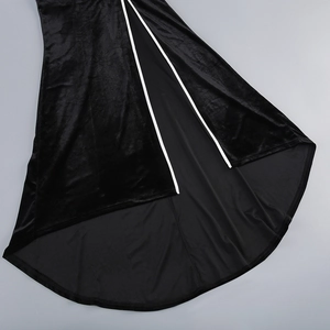 Detail of high slit velvet dress hem with contrast white trim and mermaid silhouette