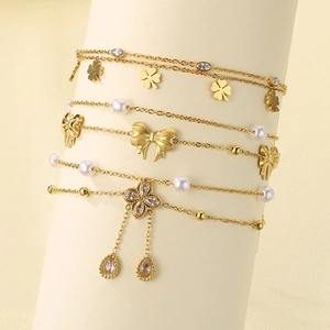 Gold multi-layer titanium ankle bracelet with pearl bow, flower charms and clover tassels