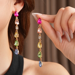 Detail of long teardrop tassel earrings with colorful sparkling crystals and gold base