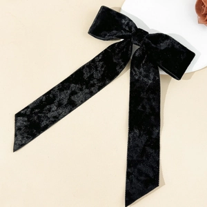 Detailed view of the soft black velvet bow hairclip with elegant long ribbon streamers