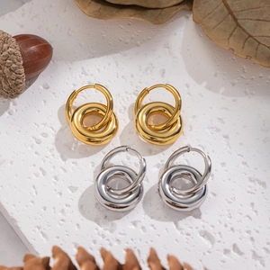 Minimalist interlocking double hoop earrings in gold and silver finish on white stone