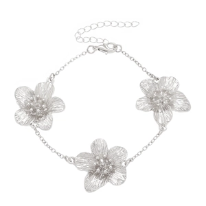 Detail of silver chain bracelet featuring three large textured metal flower charms