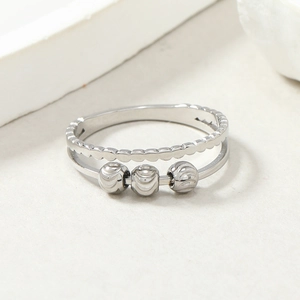 Detailed macro shot of silver stainless steel ring with three movable textured beads