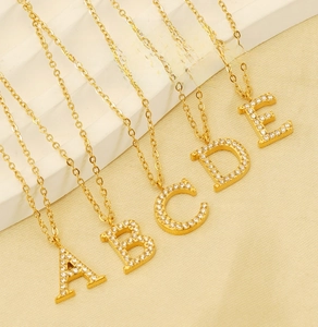 Detail of gold titanium steel necklaces with A to E zircon-inlaid initial pendants