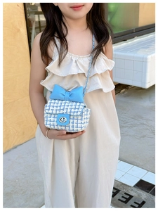 Close-up of girls blue tweed crossbody bag with large bow and metallic chain strap