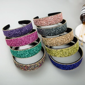 Detail of velvet headbands with sparkling glitter finish and golden beaded trim
