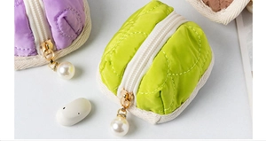 Close-up of quilted cotton earphone cases with pearl zippers in purple and green