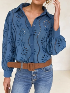 Close-up of blue hollow-out embroidery detail and lantern sleeves on a fashion shirt