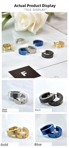 Detail view of flat stainless steel huggie earrings in silver, gold, black and blue