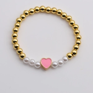 Golden beaded stretch bracelet with white pearls and a pink heart oil-drop pendant
