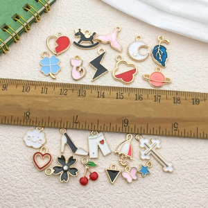 Flat lay of colorful enamel charms in shapes like hearts and stars for DIY jewelry making