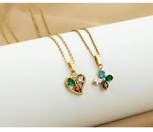 Close-up of heart and floral pendants with colorful zircon inlays on golden chain