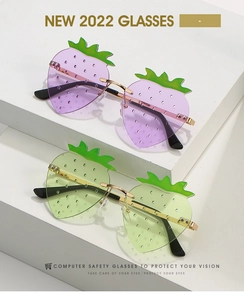 Detail of strawberry-shaped rimless glasses with green leaf accents and metal frames
