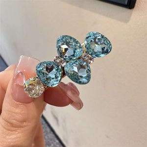 Vue détaillée de la barrette dorée ornée de cristaux en forme de goutte bleu clair
