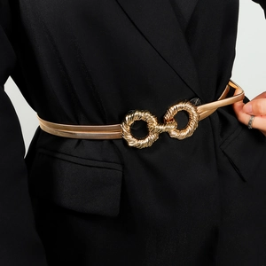 Close-up of golden spring metal waist belt with figure-eight buckle on a black suit blazer