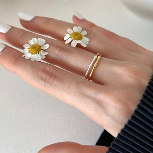 Detail shot of minimalist gold and silver bamboo rings worn on model's hand
