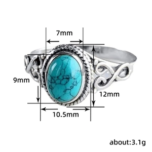 Detailed close-up of retro silver ring with turquoise stone and hollow heart patterns