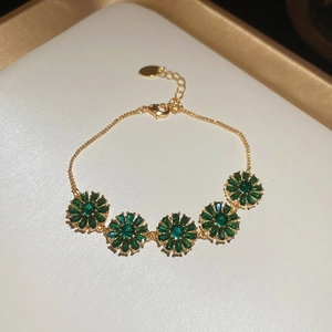 Detail of 18k gold plated bracelet featuring five green zircon flower pendants and clasp