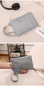 Detail of silver woven wristlet bag with gold zipper closure and stylish fabric strap