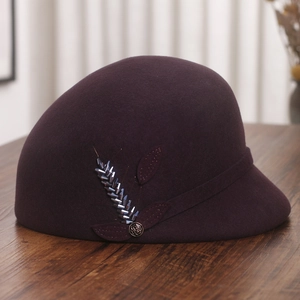 Detail of wool felt equestrian hat featuring beaded feather and rose metal buckle