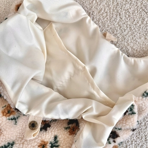 Detail view of plush floral shoulder bag showing satin lining and inner snap closure