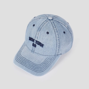 Detailed close-up of 3D New York embroidery on light blue washed denim baseball cap