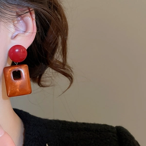 Macro view of vintage acrylic square pendant earrings on model with marble texture