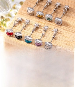 Detailed close-up of titanium steel cartilage studs with colorful shell star charms