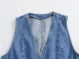 Dettaglio dello scollo a V e della trama denim di un gilet corto blu