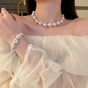 Gros plan d'un ensemble collier et bracelet en perles avec fermoir en T sur mannequin