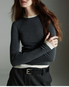 Detail of wool knit top featuring contrast trim on cuffs and premium soft texture