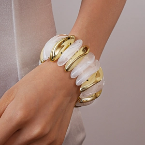 Close-up of chunky stretch bracelet featuring gold-tone metal and marble resin blocks