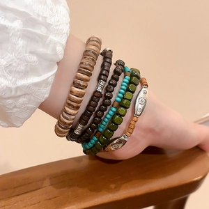 Detail of multi-layered bohemian beaded bracelets with wooden beads and turquoise accents
