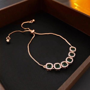 Detail of rose gold snake chain bracelet featuring five square green zircons with pave accents