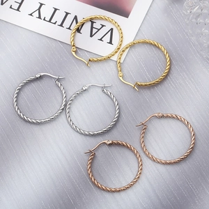 Three pairs of twisted hoop earrings in gold, silver, and rose gold stainless steel