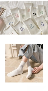 Detail of white cotton mid-calf socks with colorful cute animal embroidery and rolled edges