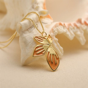 Minimalist gold chain necklace featuring an orange enamel flower petal pendant