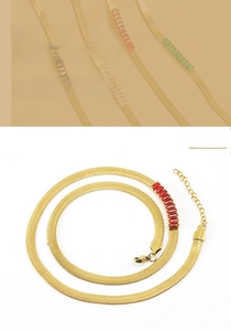 Close-up of golden flat snake chain necklace with rectangular red zircon inlay and lobster clasp