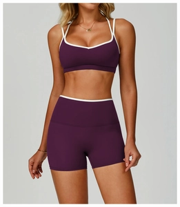 Front view of purple cross-back sports bra and high-waisted shorts with white trim