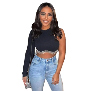 Gros plan sur un crop top noir à une épaule avec détails de franges en strass brillants