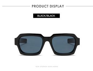 Detail view of neutral style sunglasses with high-gloss black frame and black lenses
