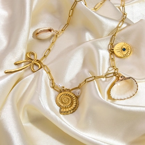 Bohemian gold stainless steel necklace with seashell and evil eye pendants on white silk