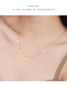 Detail view of a minimalist S925 sterling silver necklace with five round disk pendants