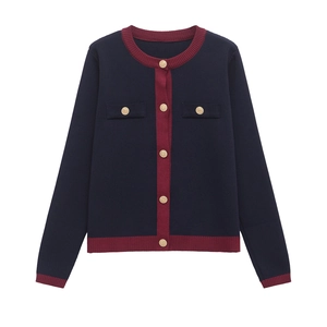 Dettaglio dei bottoni dorati e bordo bordeaux su un cardigan in maglia blu marina