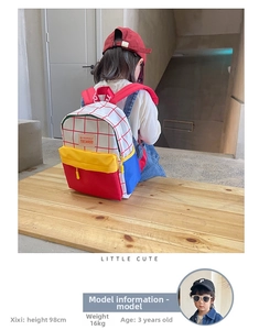 Kid back view wearing contrast color canvas backpack, 98cm tall model on wooden bench