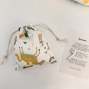 Detalle de pequeña bolsa de almacenamiento con cordón y patrones de dinosaurios