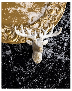 Artistic close-up of a white and gold reindeer head ornament for Christmas tree decor