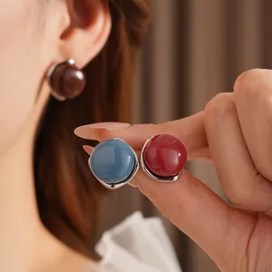 Elegant geometric sphere earrings with resin studs on textured background