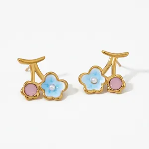 Detailed close-up of floral stud earrings with blue enamel petals and pink crystals